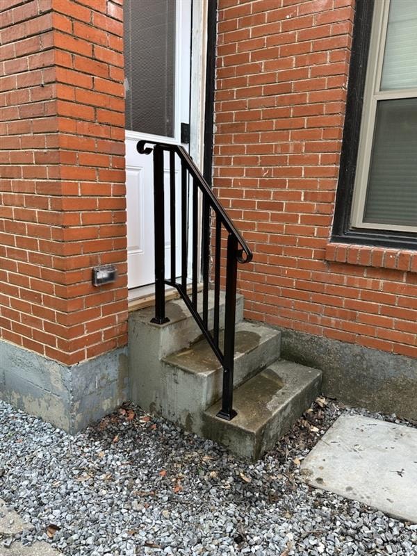 Exterior steps after — new black iron railing installed